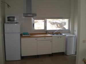 una pequeña cocina con fregadero y ventana en La Aldea, en Calles