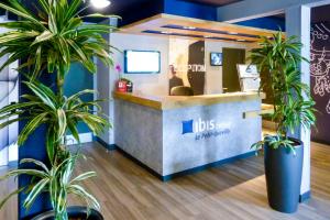 a job shop with potted plants in front of a counter at Ibis budget Rouen Petit Quevilly in Le Petit-Quevilly