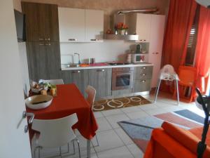 チェリアーレにあるCasa Domenica al mareの小さなキッチン(赤いテーブルと椅子付)