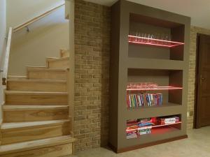 a staircase with a brick wall and a book shelf at Dom wypoczynkowy Sosenka in Orzysz