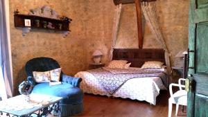 a bedroom with a bed and a chair at La Ferme de Jeanne in Saint-Girons +142 photos