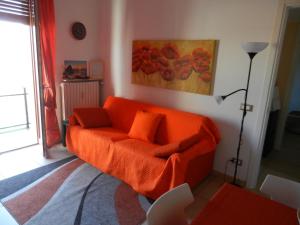 an orange couch in a living room with a painting at Casa Domenica - 200m dal mare in Ceriale
