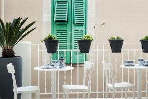 a table and chairs in front of a green door at MoMa Business Apartments in Molfetta