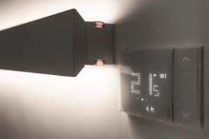 a clock on a wall with a light on it at MoMa Business Apartments in Molfetta