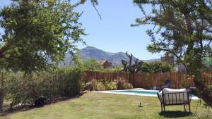a yard with a chair next to a swimming pool at Septimo Sol in Capilla del Monte
