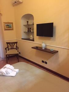 pokój z łóżkiem i telewizorem na ścianie w obiekcie B&B Lumasa w mieście Vietri sul Mare