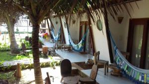a group of hammocks in a resort with palm trees at Beijo Mar Beach Club in Tibau