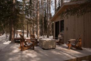 a group of wooden tables and chairs on a patio at Auberge le Cosy in La Conception
