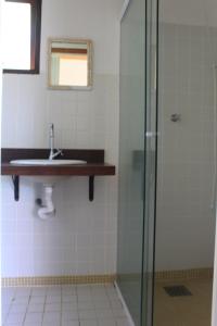 a bathroom with a glass shower and a sink at Pousada O Canto das Sereias in Trindade