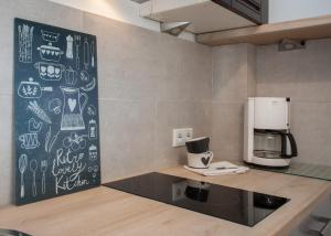 a kitchen with a counter with a coffee maker on a wall at Appartement Maya in Winterberg