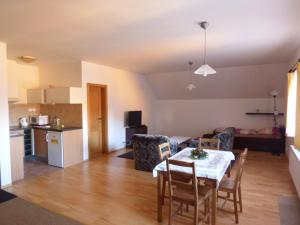 a kitchen and a living room with a table and chairs at Chata Albrechta in Albrechtice v Jizerských horách