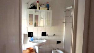 a white bathroom with a sink and a mirror at Casa Cordati in Barga