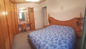 een slaapkamer met een bed, een bureau en een spiegel bij Dreaming Ortisei in Ortisei