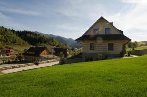 uma casa ao lado de uma colina verde em Drevenica Nela em Zuberec