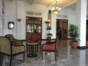 un hall avec des chaises et une table dans un bâtiment dans l'établissement Shalimar Hotel, à Colombo