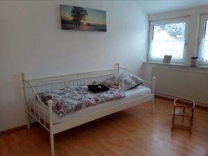 a white bed in a room with a window at Mia und Michel im Sauerland in Bad Berleburg