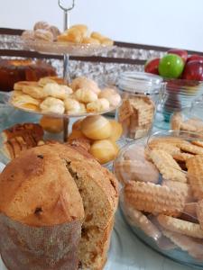uma mesa com diferentes tipos de pão e pastelaria em Pousada Lugama em Bento Gonçalves