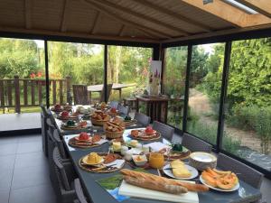 długi stół pełen jedzenia na patio w obiekcie Chambres d'Hôtes Le Moulin du Pont w mieście Saint-Bonnet-de-Salers