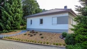 a small white house with a driveway at Ferienhaus im Erzgebirge in Chemnitz