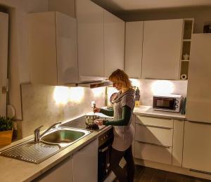 a woman standing in a kitchen preparing food at Ferienhaus im Erzgebirge in Chemnitz