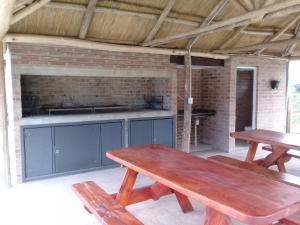 una mesa de picnic y bancos en una cocina al aire libre en Cabañas Villa del Mirador, en Bialet Massé