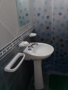 Un baño con un lavabo blanco y un espejo. en Cabañas Villa del Mirador, en Bialet Massé