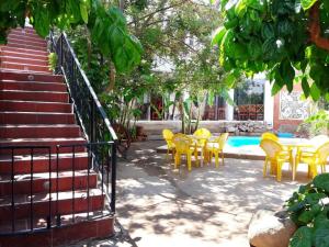 patio z żółtymi krzesłami i stołami oraz basenem w obiekcie El Viejo Molino w mieście Chilecito