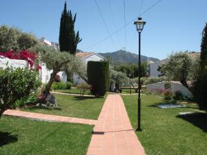 a brick path in a yard with a street light at El Capistrano Sur in Nerja