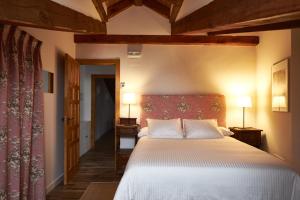 a bedroom with a large bed and two lamps at Casa Rural Victoriano Pedraza in Rades de Abajo