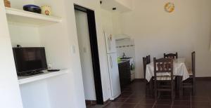 a living room with a television and a table with chairs at Verbenas de las Sierras in Cortaderas