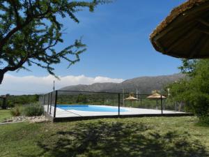 a swimming pool in a garden with mountains in the background at Verbenas de las Sierras in Cortaderas