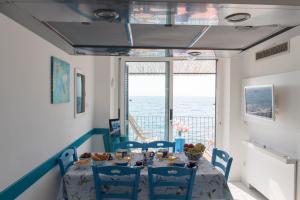 a dining room with a table and chairs and a window at L'Oblò in Massa Lubrense