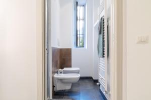 ミラノにあるCharming Sempione Apartmentのバスルーム(白いトイレ、窓付)