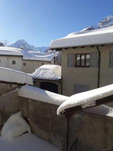 a snow covered roof of a house with buildings at La Tana Del Lupo in Entracque