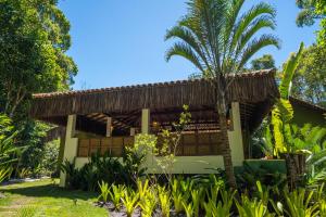 a resort with a palm tree in front of it at Casa do Arvoredo in Trancoso