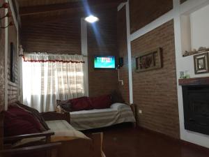 a living room with a couch and a tv at Cerro Molinos in Potrero de Garay