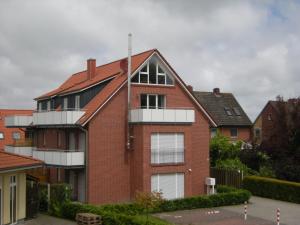 Casa de ladrillo con ventanas blancas y techo en Strandblick, en Horumersiel