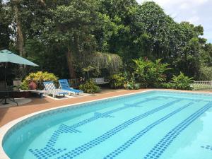 a swimming pool with two chairs and an umbrella at Finca Machangara in Quimbaya