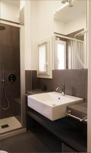 une salle de bain avec un lavabo blanc et une douche dans l'établissement Residenza Pellacani, à Bologne