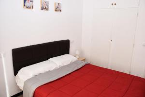 a bedroom with a bed with a red blanket at Rosesapparts Onamar & Parking in Roses