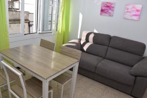 uma sala de estar com um sofá e uma mesa em Rosesapparts Onamar & Parking em Roses