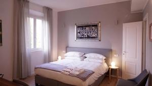 une chambre avec un lit avec des draps blancs et des oreillers dans l'établissement Residenza Pellacani, à Bologne