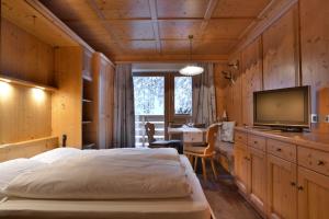 ein Schlafzimmer mit Bett und Flachbildfernseher in der Unterkunft Residence Ciasa Vedla in Abtei + 38 Fotos