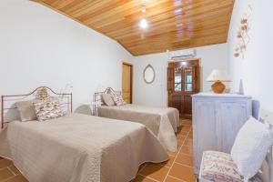 a bedroom with two beds and a wooden ceiling at Varanda do Mouro in Podame +23 photos