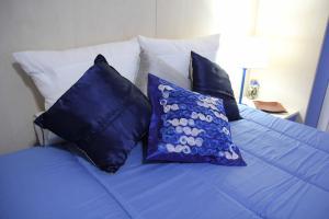 a blue bed with blue pillows on it at Il Giardino delle Jacaranda in Talsano
