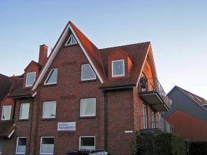 a red brick building with a gambrel roof at Strandbad in Horumersiel +7 photos