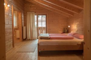 a bedroom with a bed in a wooden house at Oberschupferhof in Außervillgraten