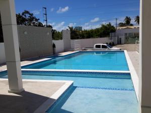 a large blue swimming pool in a yard at Ótima Localização - 4 Quartos in Porto Seguro