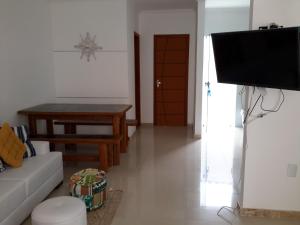 un soggiorno con un divano e una televisione di Ótima Localização - 4 Quartos a Porto Seguro