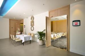 a dining room with a white table and chairs at Ibis Phuket Kata in Kata Beach
